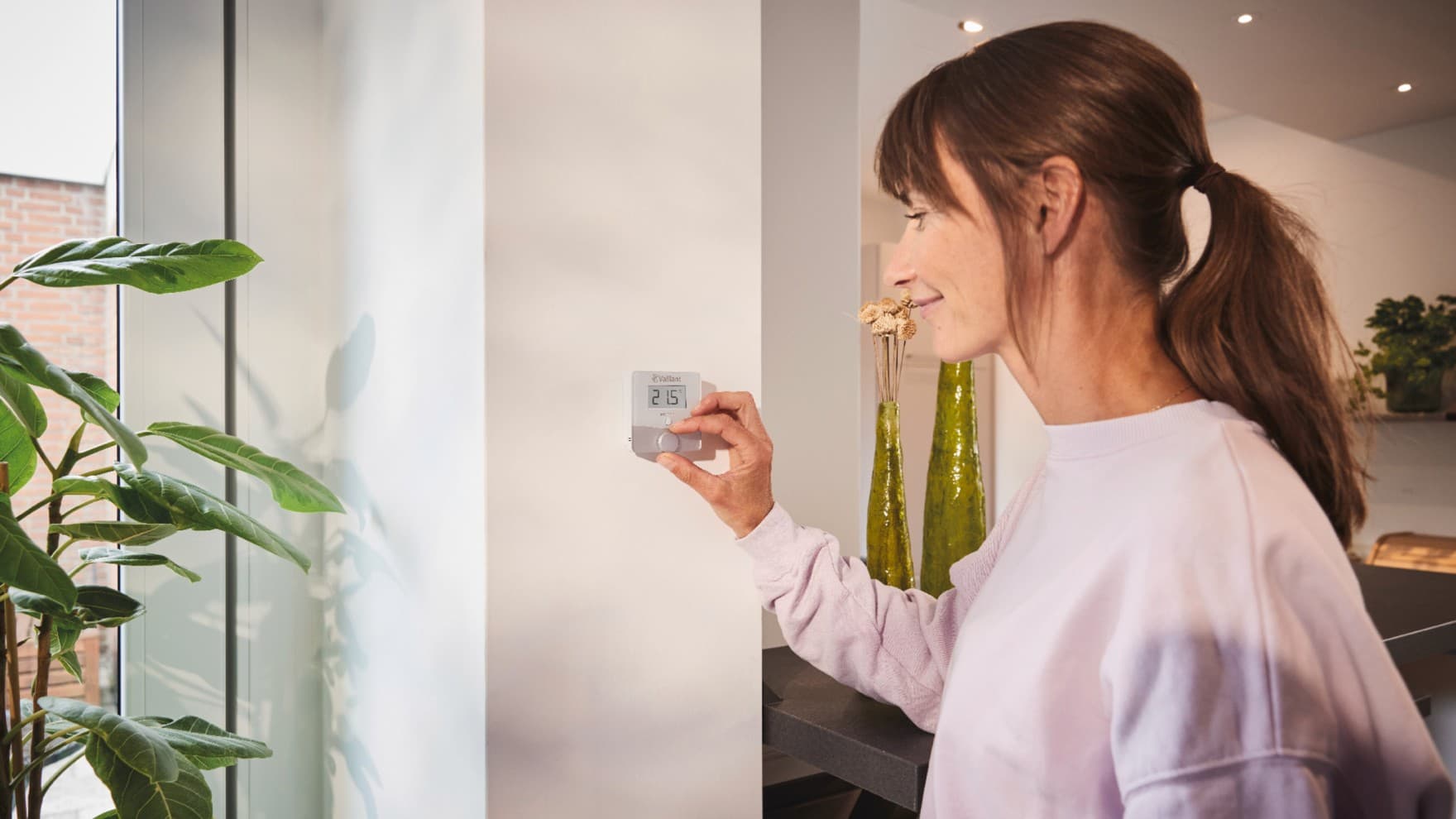 Žena používající termostat Vaillant sensoROOM
