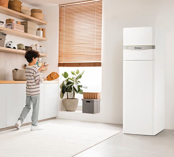 Chlapec si hraje v technické místnosti s modelem Vaillant flexoCOMPACT exclusive
