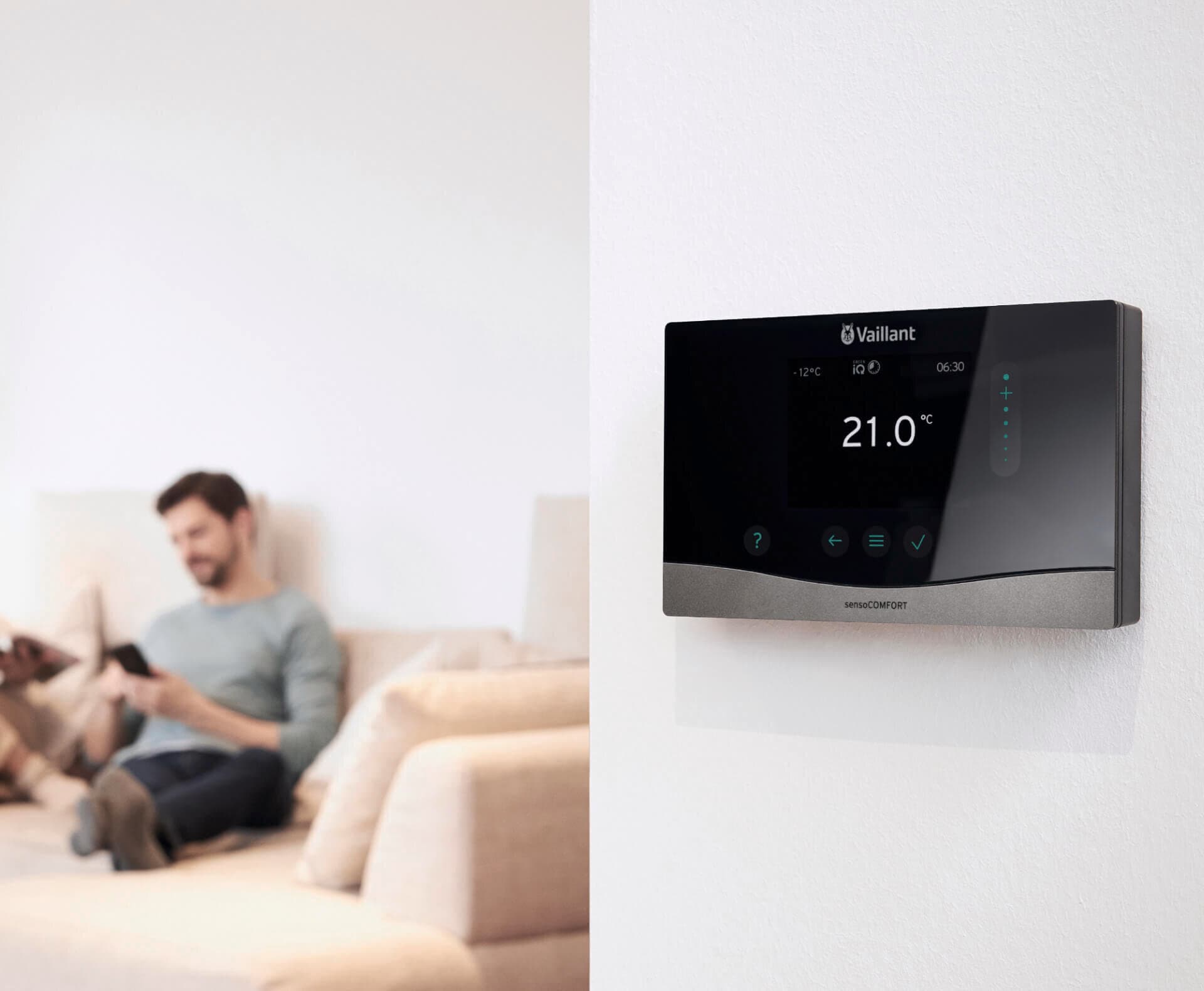 Muž sedící na pohovce, před sebou má zařízení sensoCOMFORT