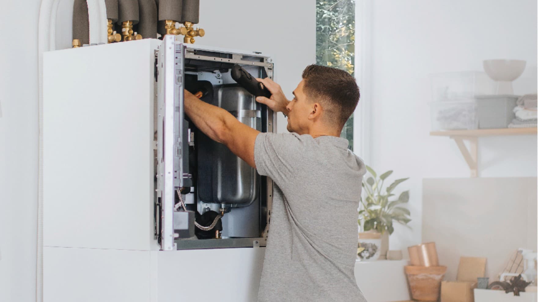 Instalatér pracující na vnitřní jednotce tepelného čerpadla